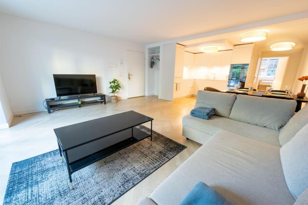 a living room with a couch and a table at Ground floor apartment - Peaceful living in the city of Zürich in Zürich