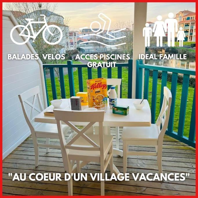 - une table et des chaises blanches sur un balcon avec un vélo dans l'établissement 