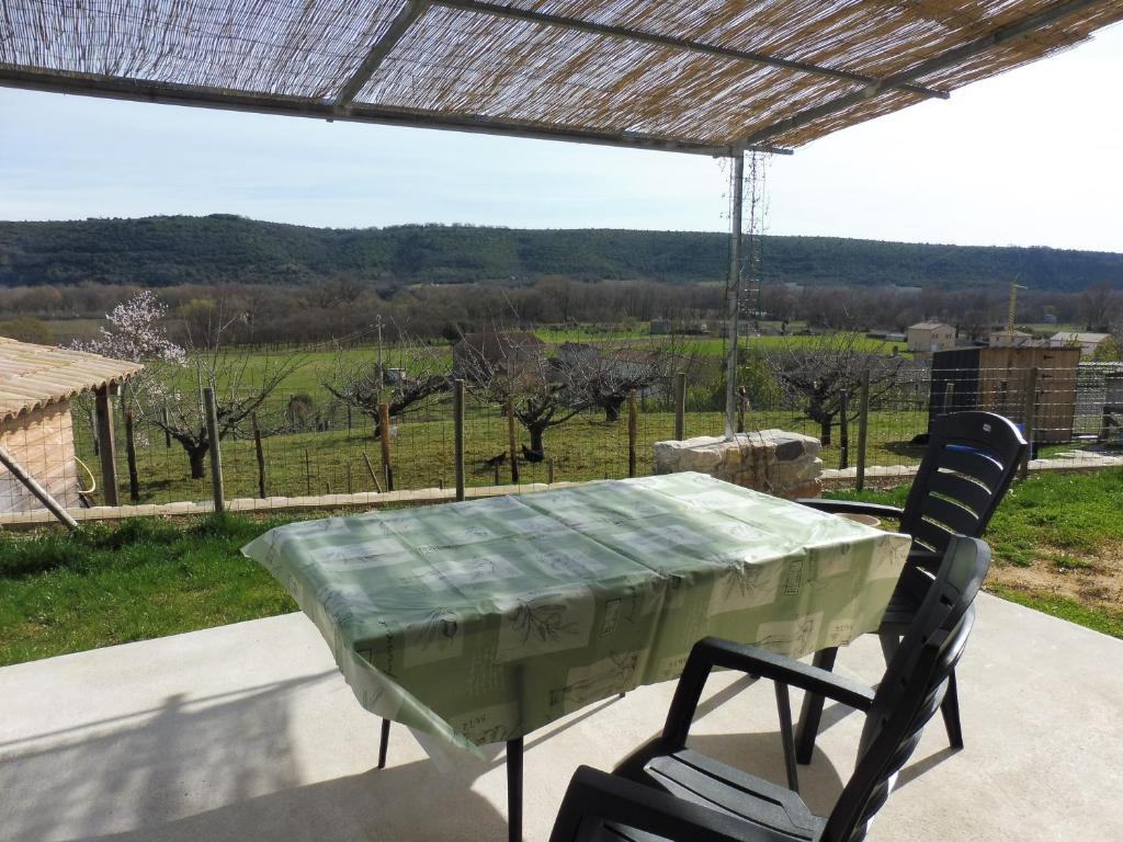 a table and chairs on a patio with a view at Gîte Amour D&#39;ardèche in Saint-Sernin