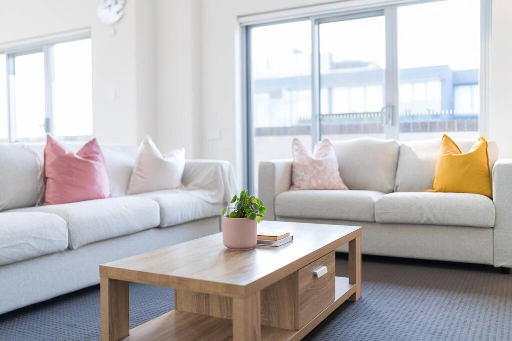 a living room with a couch and a coffee table at Spacious 3 bed apartment near airport with parking in Sydney