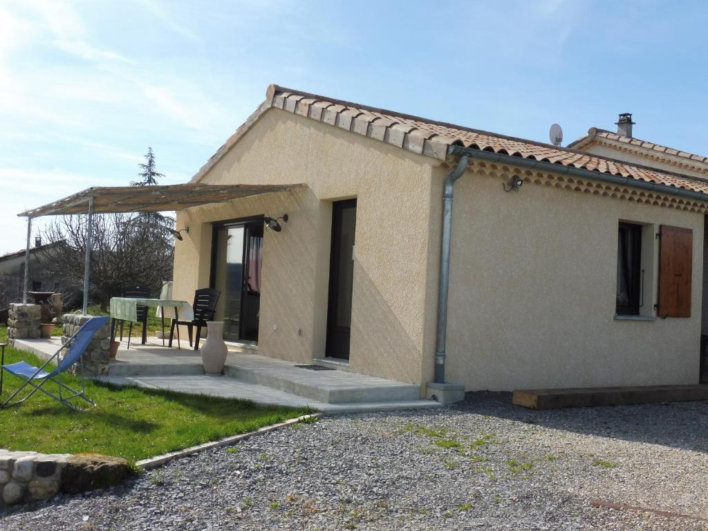 a small house with a table and a patio at Gîte Amour D&#39;ardèche in Saint-Sernin