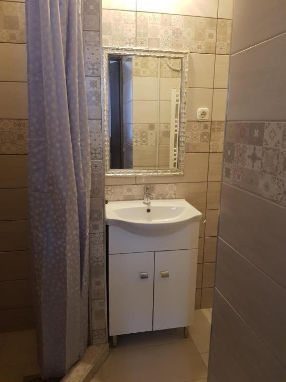 a bathroom with a sink and a mirror at Aranyos Apartman in Hajdúszoboszló