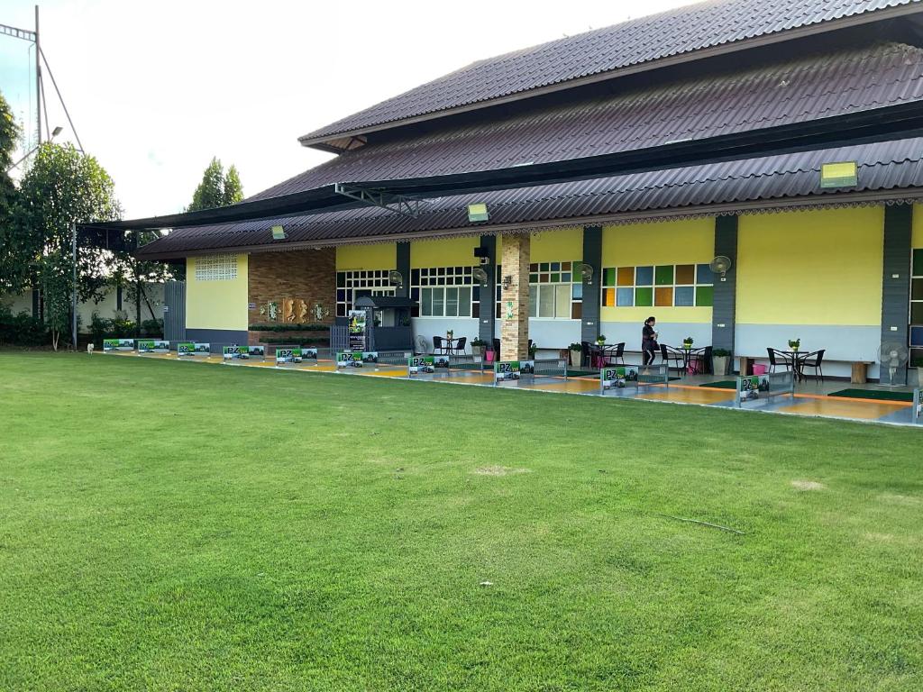 un bâtiment avec une pelouse devant lui dans l'établissement PZ วิวล์, à Ban Mae Lai