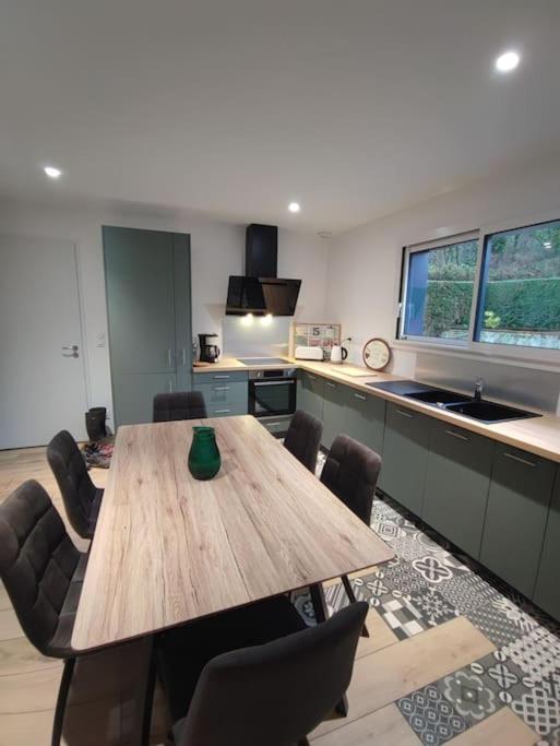 une cuisine avec une table en bois et quelques chaises dans l'établissement Chez Mémère, à Colleville-sur-Mer