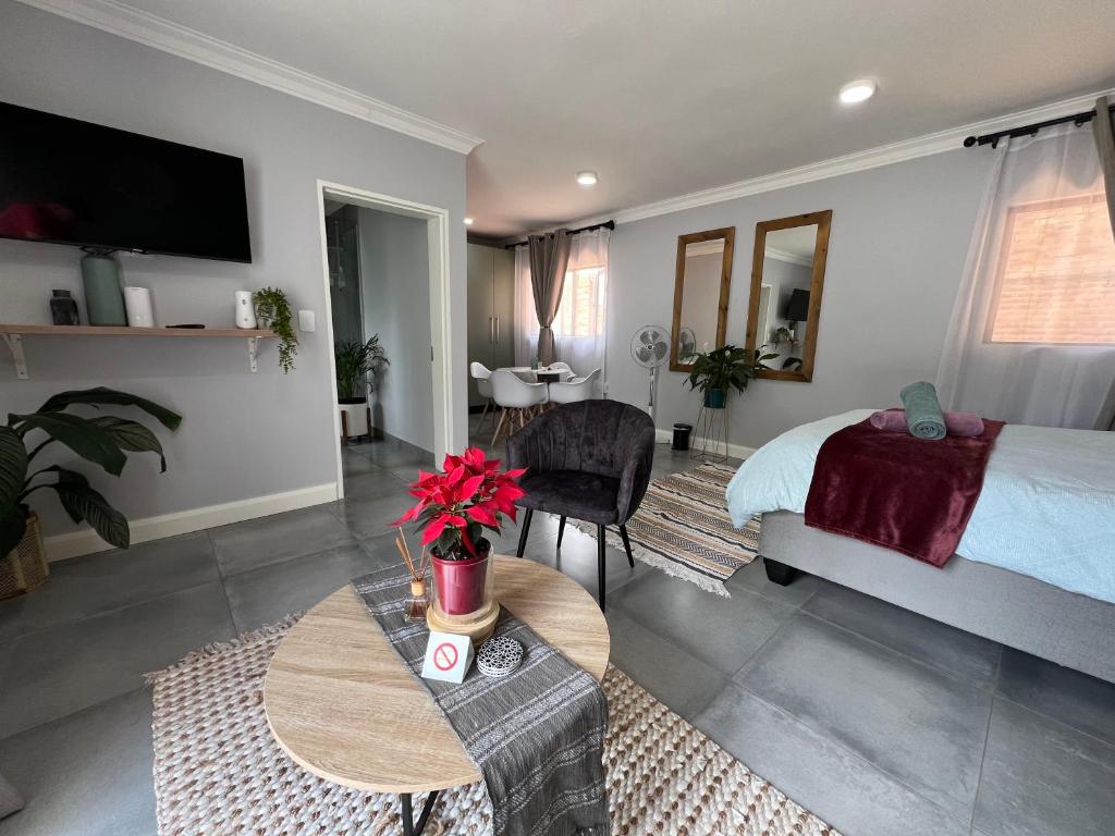 een slaapkamer met een bed en een tafel in een kamer bij Afrique134 Olive Tree Private Courtyard Suite in Pretoria
