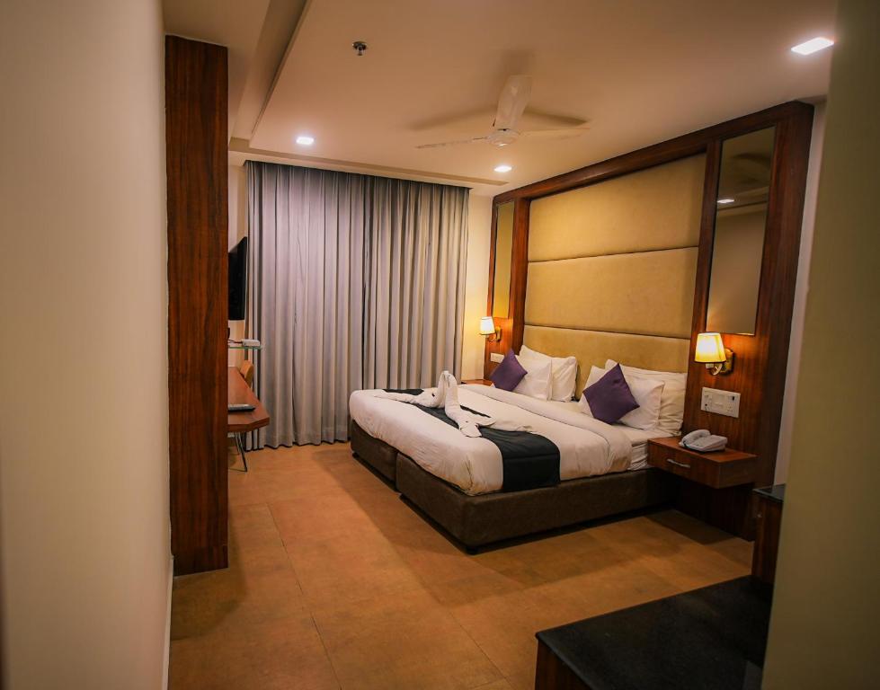 a hotel room with a bed and a mirror at Dazzling in Agra