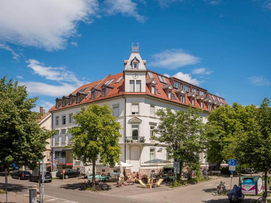 a large white building with a red roof at Moderne Apartments in attraktivem Altbau in Freiburg im Breisgau