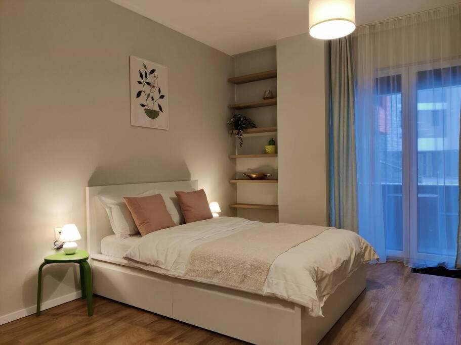 een slaapkamer met een groot bed en een raam bij Joy City Stay Armoniei 01 in Timişoara