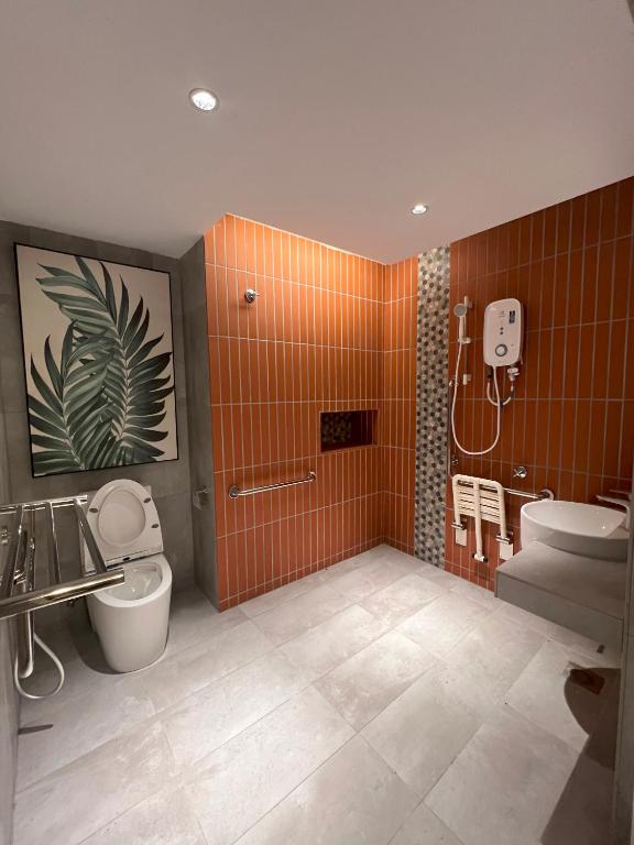 A bright tiled bathroom includes a toilet, vanity, handheld shower and wall-mounted water heater.