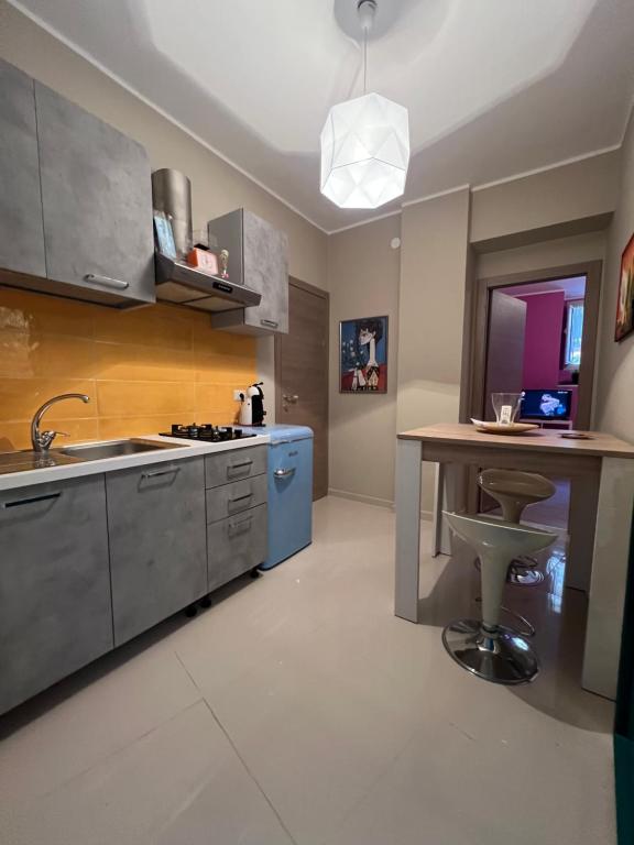 a kitchen with a sink and a table in it at Tavernetta Cortile Dalmazia in Catania