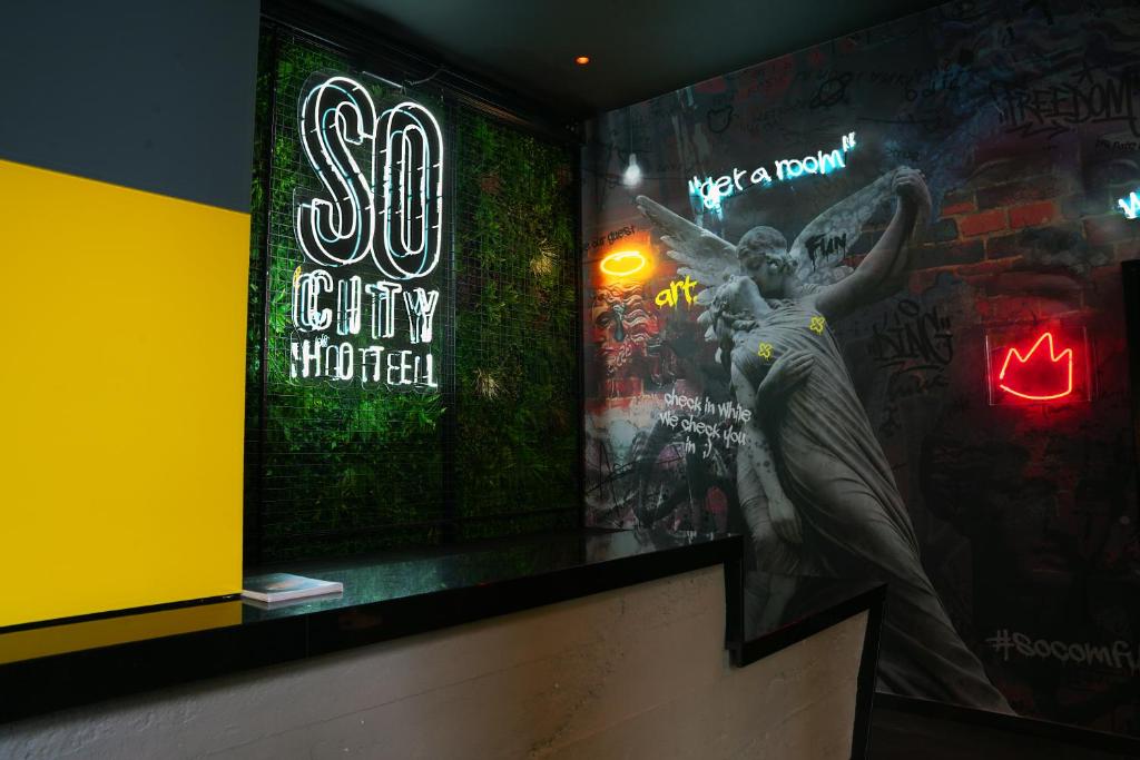 a mural of a woman on a wall with graffiti at SO City Hotel Adults Only in St. Julianʼs