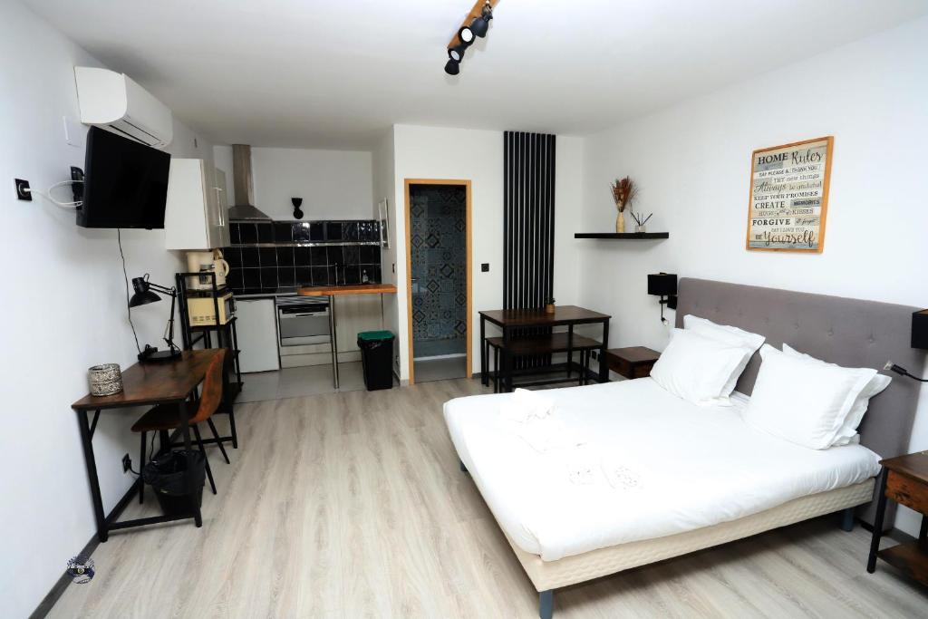 1 dormitorio con 1 cama blanca y cocina en Apparts' hôtel Casa di a Restonica en Corte