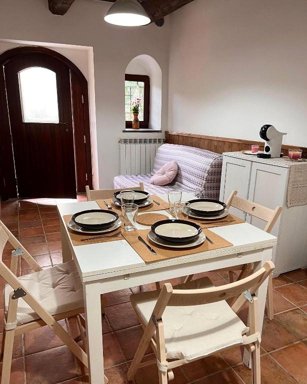 una sala da pranzo con tavolo e sedie bianchi di Castelvecchio 168 a Sarnano
