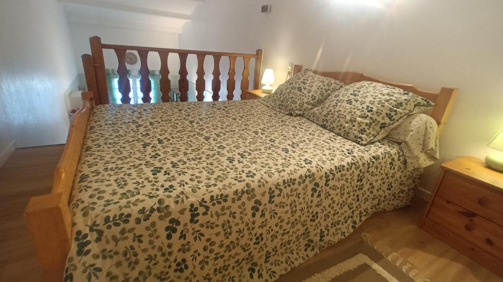een slaapkamer met een bed met een houten hoofdeinde bij Les coquelicots. in Mirepoix