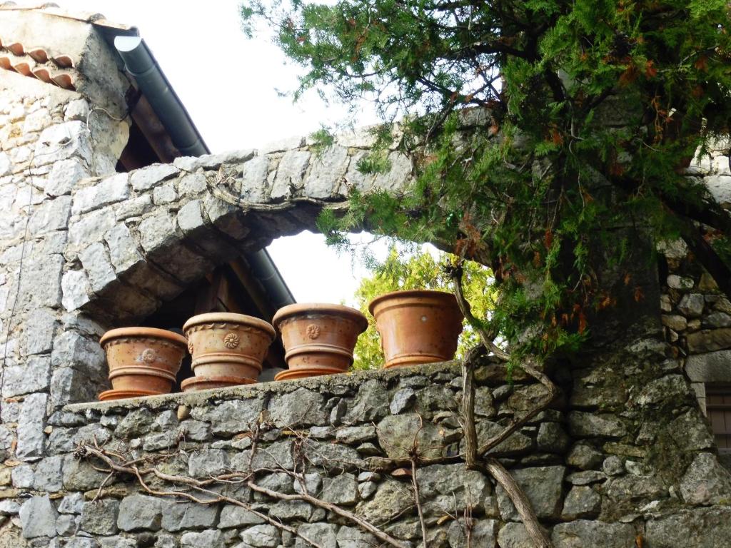 a group of clay pots sitting on a stone wall at Gîte Amour D&#39;ardèche in Saint-Sernin