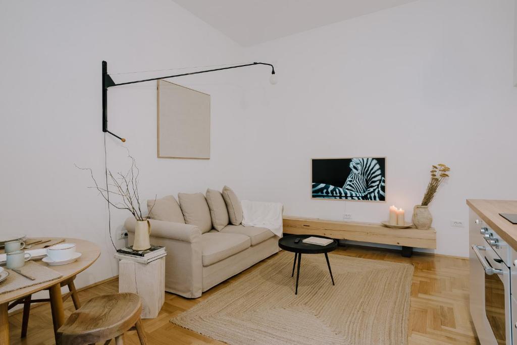 ein Wohnzimmer mit einem Sofa und einem Tisch in der Unterkunft LUCCA in Zagreb