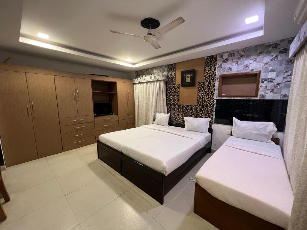 a bedroom with two beds and aiflower at Vishranthi Home Stay in Chennai