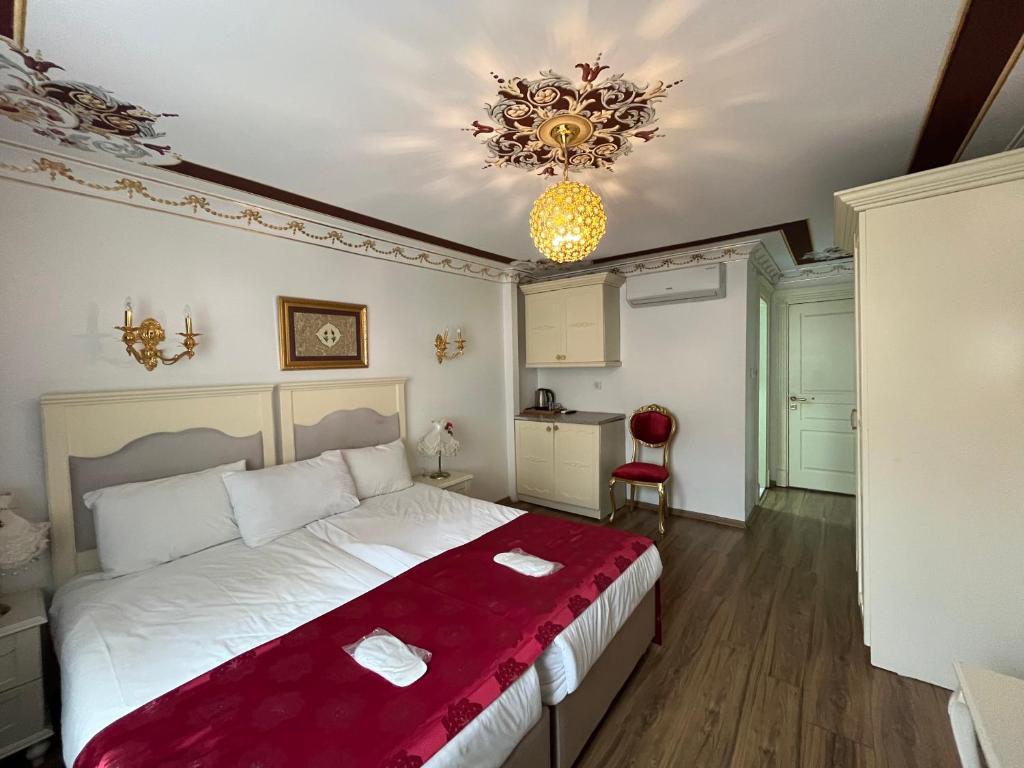 a bedroom with a large bed and a chandelier at Golden Hotel Old City in Istanbul