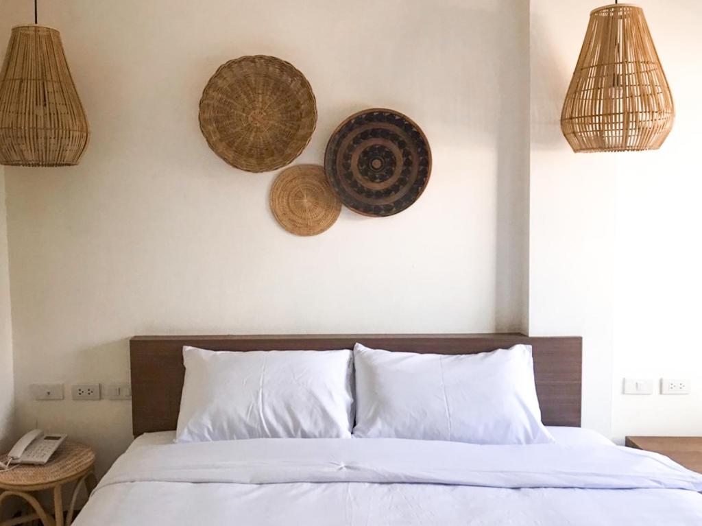 a bedroom with a bed with two baskets on the wall at บ้านสวนอินทาวน์ Baansuan in Town Hotel in Chiang Mai