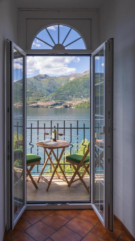 a room with a balcony with a table and a view at Casa Emi in Lezzeno