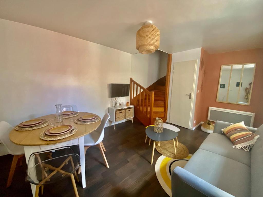 a living room with a table and a couch at Le Carnot: city centre with parking space in Poitiers