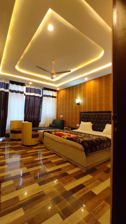 a bedroom with a large bed in a room with a wooden floor at Tirupati Hotel in Kotdwāra