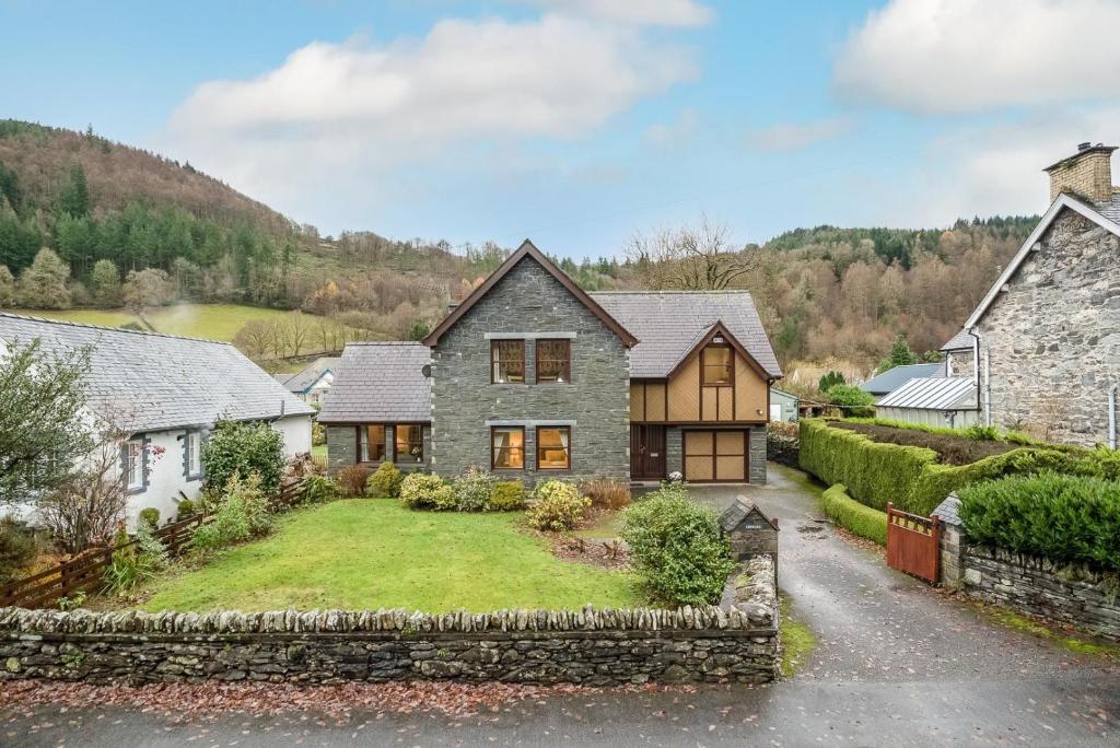 una vista esterna di una casa con un muro in pietra di Creigia-Betws a Betws-y-coed