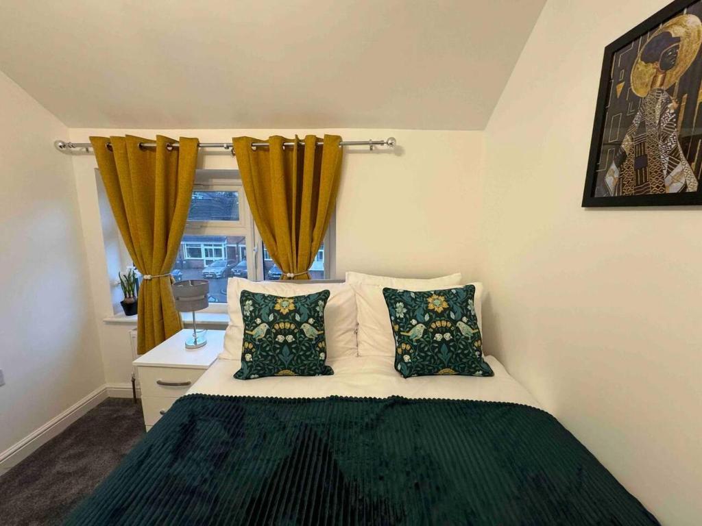 a bedroom with a bed with two pillows and a window at The Ideal Beautiful 3-Bed House in Birmingham in Birmingham