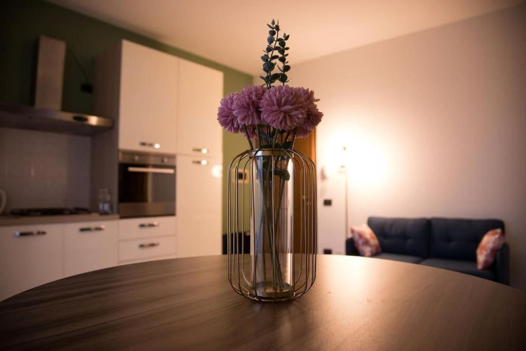 um vaso com flores roxas em cima de uma mesa em Afittacamere L'Agorà em Piacenza