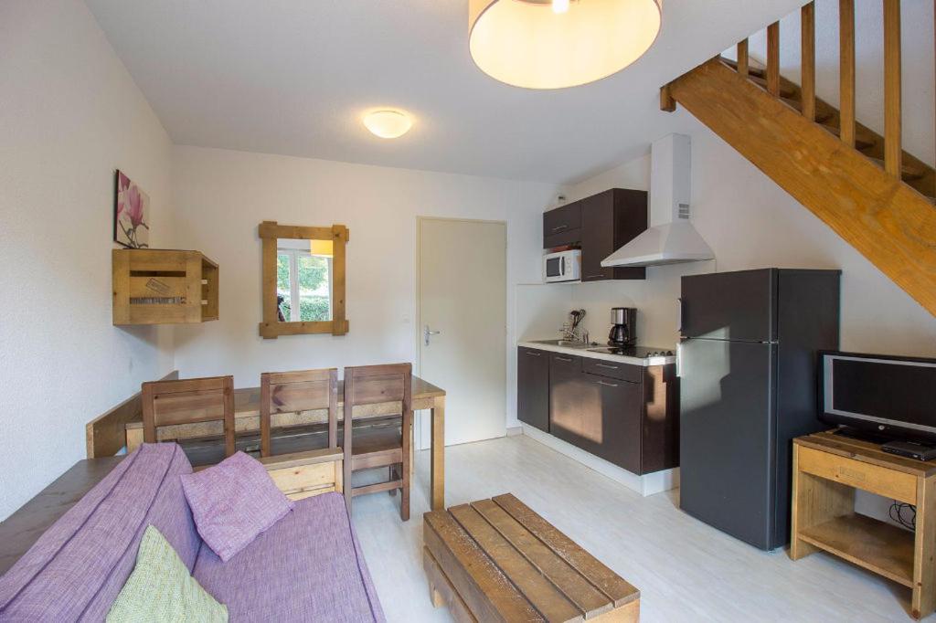 uma sala de estar com uma cozinha e uma sala de jantar em Les Terrasses du Lac J43 em Aureilhan