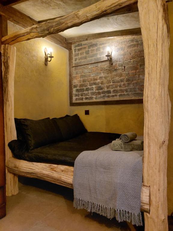 a bed in a room with a brick wall at A little bit of Magic - Witchcraft in York