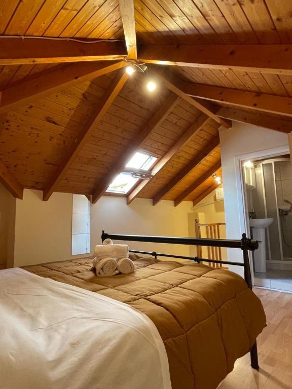 een slaapkamer met een groot bed en houten plafonds bij Οι Φωλίτσες in Nafpaktos