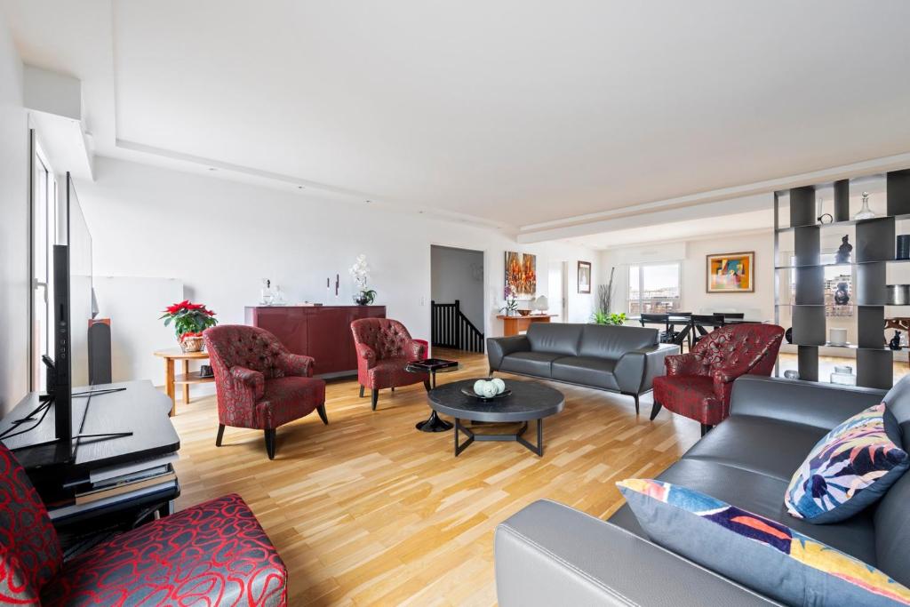 un salon avec un canapé, des chaises et une table dans l'établissement Veeve - Abstract Allure, à Paris