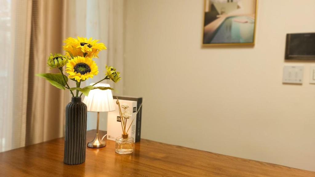 a vase with sunflowers in it sitting on a table at Adi Stay in Seoul