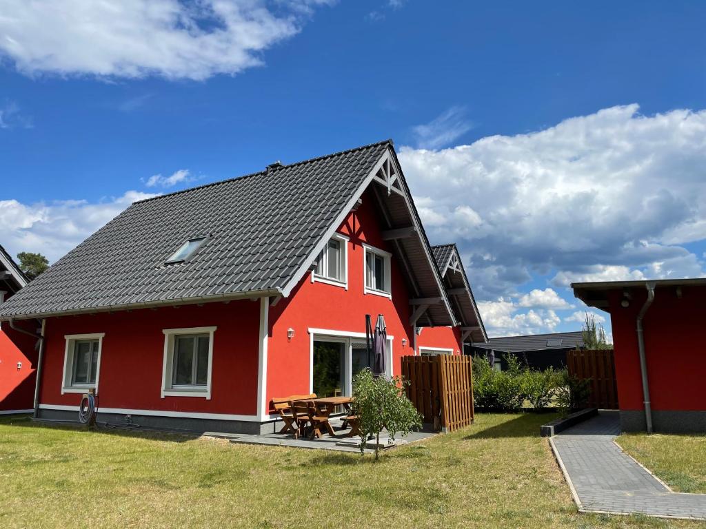 une maison rouge avec un toit noir dans l'établissement Urlaub am Plätlinsee - Haus Odin, à Wustrow