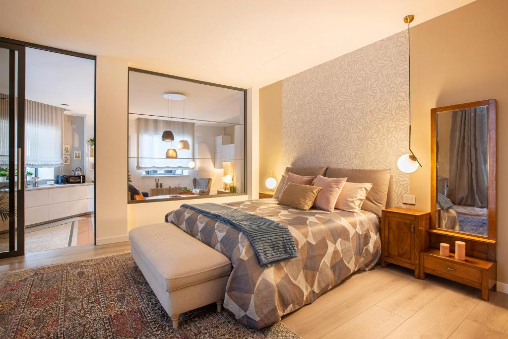 1 dormitorio con cama y espejo grande en TRENTINO LODGE Piazza Municipio, en Strigno