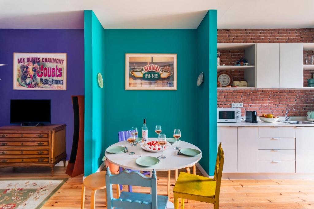a dining room with a table and a blue wall at Monica's Groove: a Friends' Inspired Apartment in Lisbon