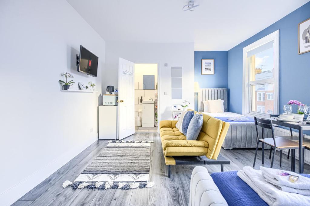 a living room with a yellow couch and a dining room at Hackney Central Deluxe Apartment in London