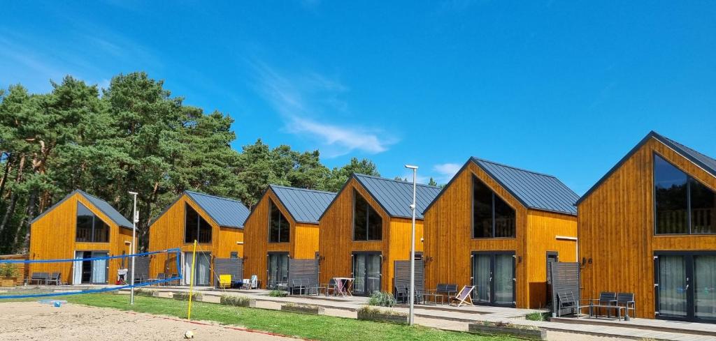 a row of wooden houses in a row at Piaski Rogowa in Rogowo