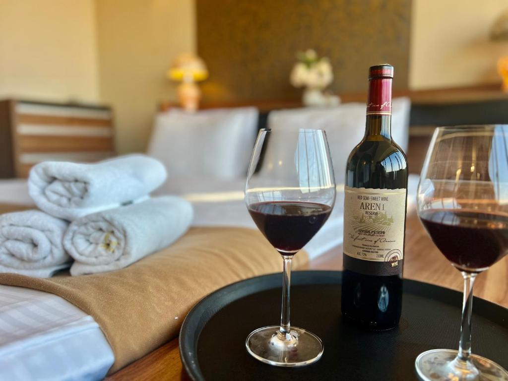 Una botella de vino y dos copas en una mesa. en Sky Magic view Hotel, en Ereván