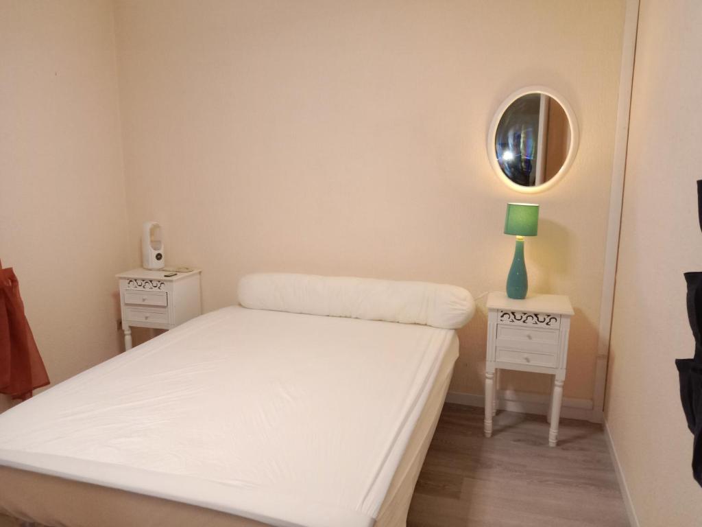 een kleine slaapkamer met een bed en een spiegel bij Chambres d'hôtes Ruoms sud Ardèche in Ruoms