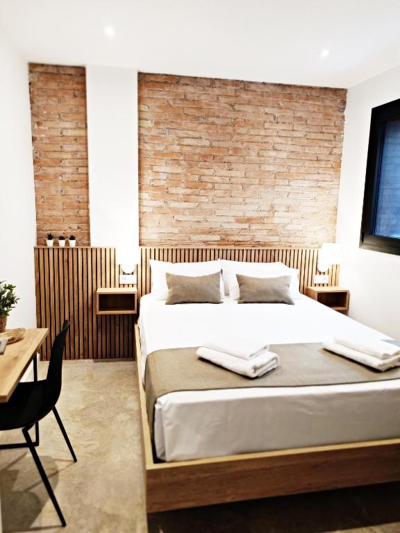 略夫雷加特河畔奥斯皮塔莱特ARIQUS Fira Apartments的一间带床和砖墙的卧室