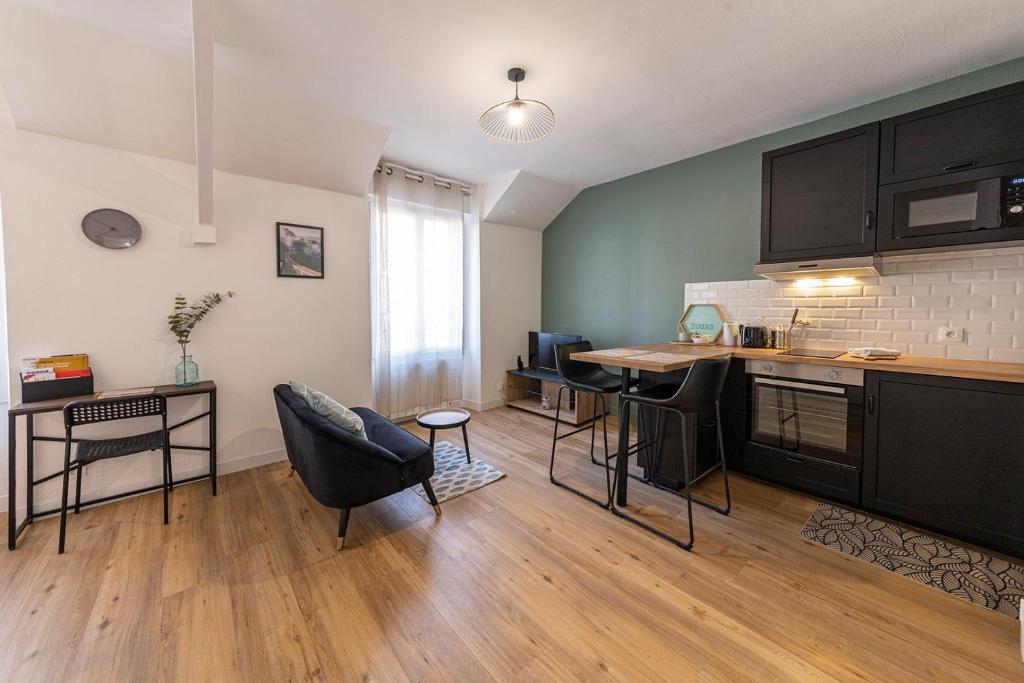 eine Küche mit einem Tisch und Stühlen im Zimmer in der Unterkunft Coquelin - Joli appartement rénové in Rennes