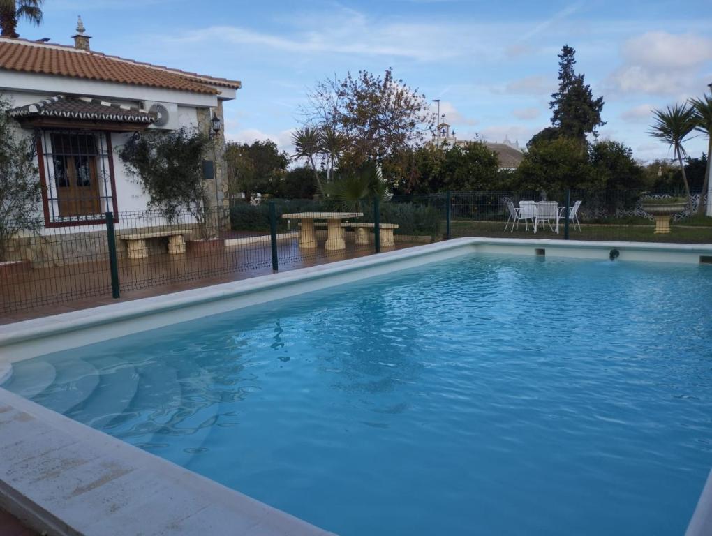 una gran piscina azul frente a una casa en Villa Romero, en Mairena del Alcor