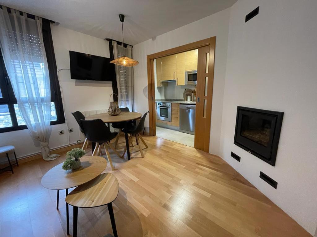Una sala de estar con mesa y sillas y una cocina. en Apartamento La Añaza, en Villanúa