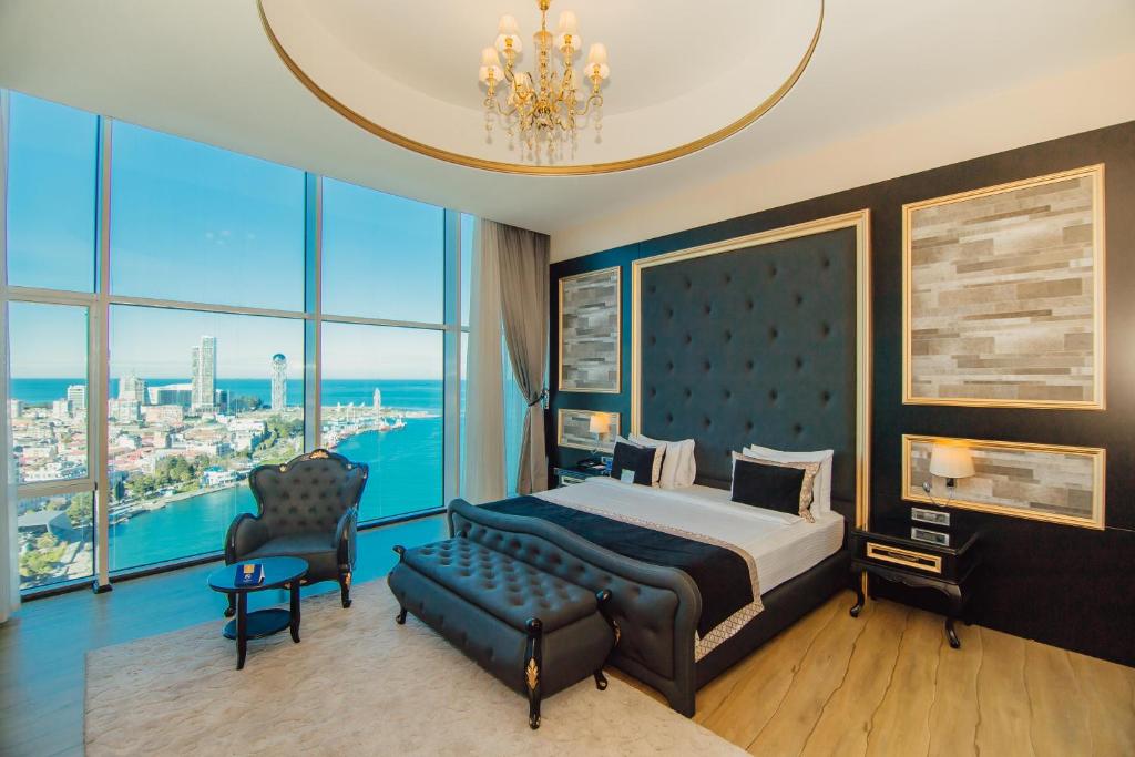 sypialnia z łóżkiem, krzesłem i oknami w obiekcie JRW Welmond Hotel w mieście Batumi