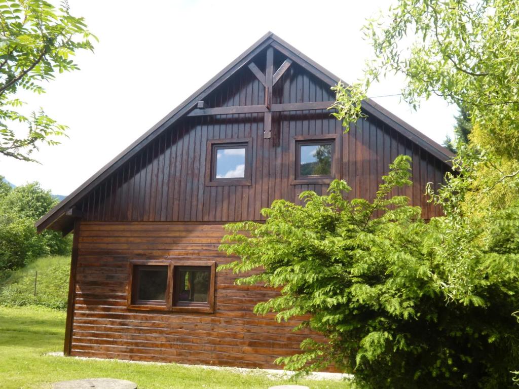 una casa de madera con techo de gambrel en Chata v Beskydech en Ostravice