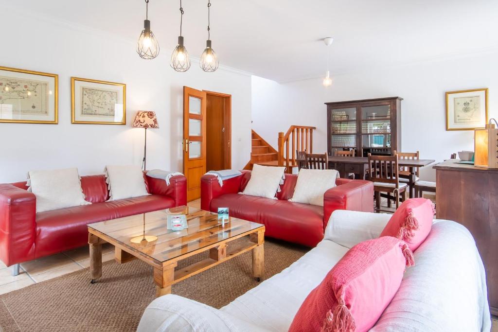 Sala de estar con sofás rojos y mesa de centro en Casa dos Minaus by LovelyStay, en Santo Isidoro