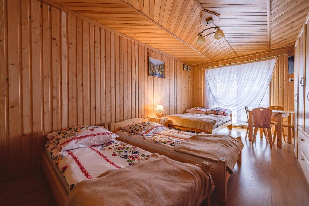 um quarto com três camas e uma mesa em U Marii & Mariana em Leśnica