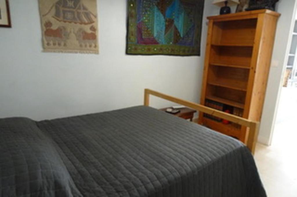 une chambre avec un lit et une étagère dans l'établissement A proximité du Mont Ventoux, à Carpentras